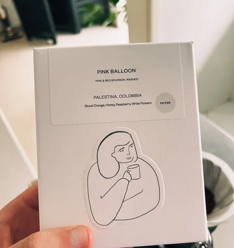 Caixa de café Pink Balloon, com ilustração de uma moça segurando uma xícara