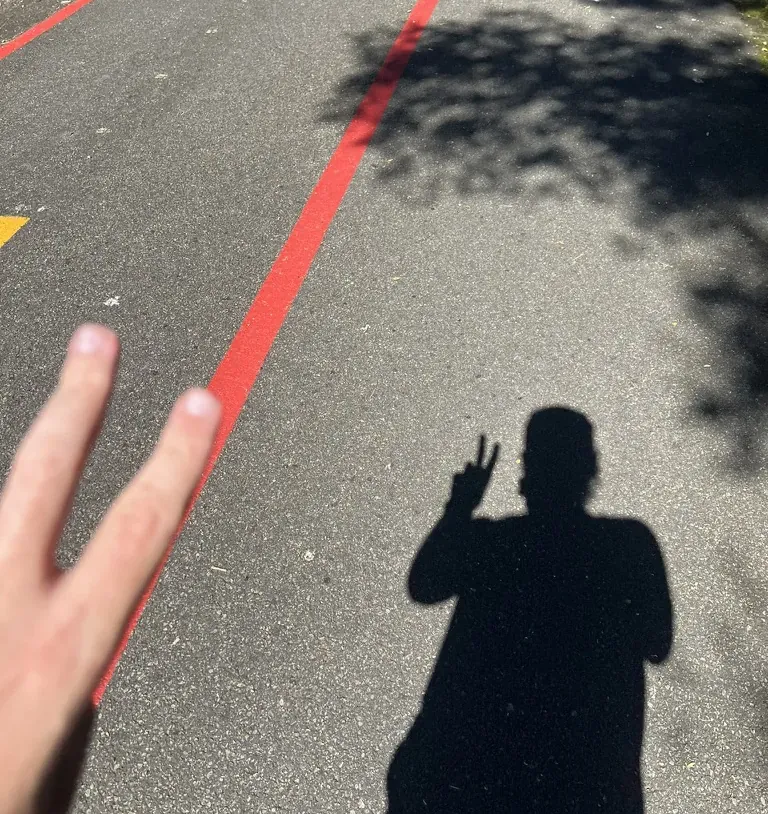 A sombra do Leo acenando na ciclovia durante uma corrida
