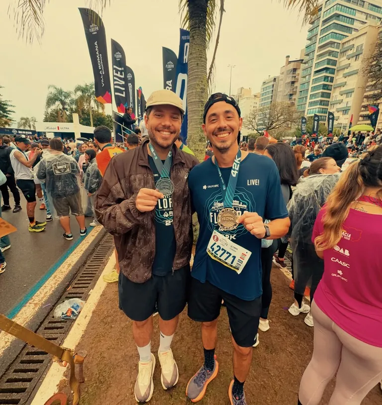 Leo e um amigo depois da maratona de Florianópolis, cada um mostrando a medalha