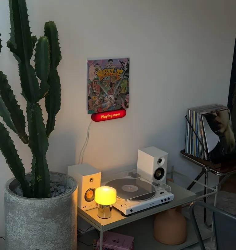 O canto da vitrola, com um cacto e o rádio aceso